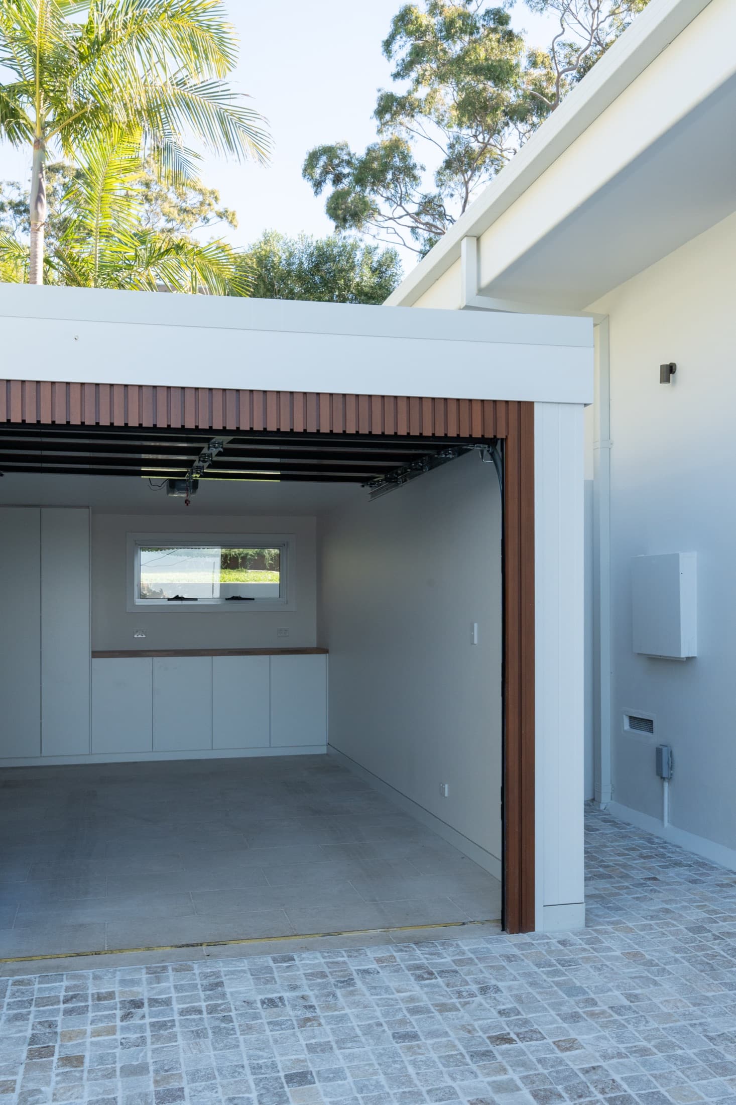 The same view after: the rebuilt garage, lined and finished, over a cobblestone apron
